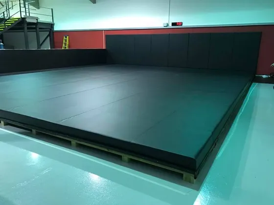 Black vinyl floor cover with extra wall covers for raised gym area.